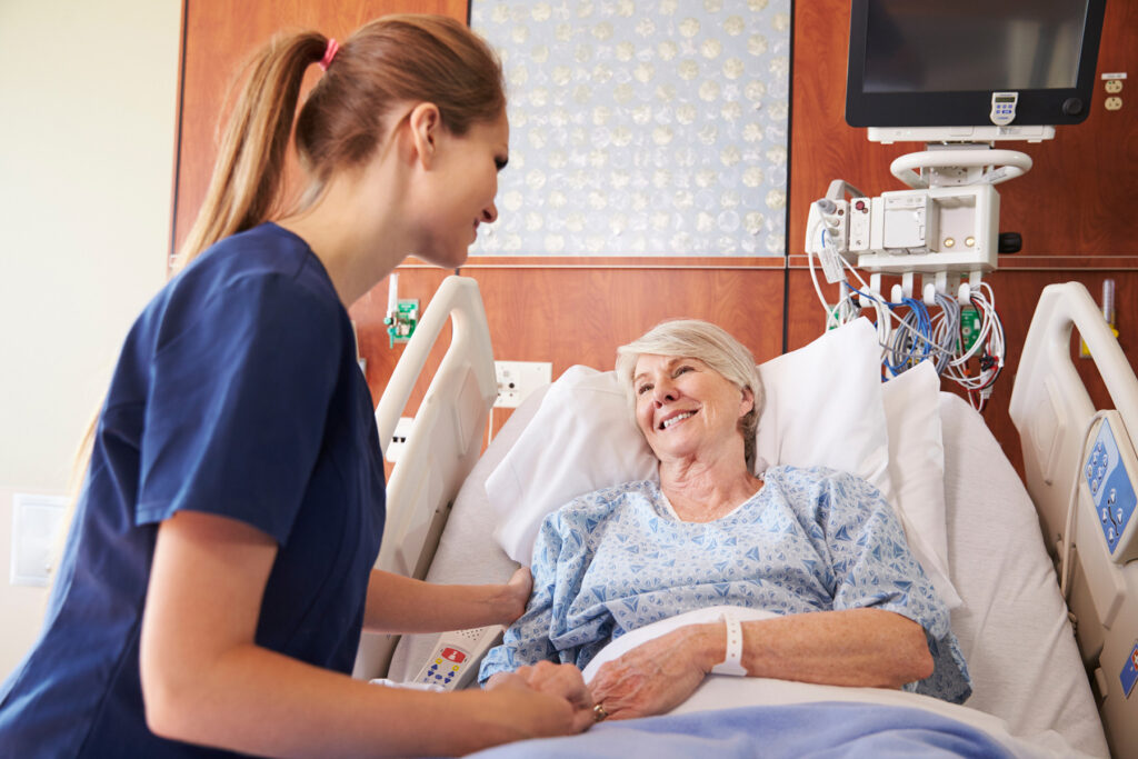Nurse comforting patient in hospital bed